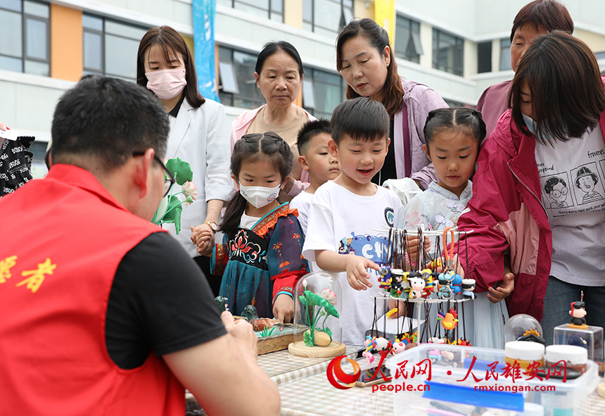 5月31日，雄安容和樂(lè)安幼兒園舉辦傳統(tǒng)文化游園活動(dòng)。活動(dòng)邀請(qǐng)了雄安當(dāng)?shù)胤沁z文化傳承人走進(jìn)幼兒園，與孩子和家長(zhǎng)交流互動(dòng)。通過(guò)現(xiàn)場(chǎng)接觸非遺項(xiàng)目，讓孩子們零距離認(rèn)識(shí)非遺、熟悉非遺，感受非遺之美。人民網(wǎng) 李兆民攝